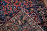Vintage Lilihan rug corner folded back, revealing the hand-knotted weave and dusty rose floral pile.