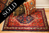 Intricate geometric red and blue border of the hand-knotted vintage Persian rug.