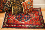 Bold red Northwest Persian rug with a navy geometric medallion and detailed borders, 2'1