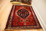 Upper right corner of the red Persian rug, showing its bold geometric border designs.