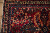 Corner view of a vintage Sarouk rug highlighting the floral borders and hand-knotted texture.