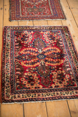 A vintage Persian Sarouk mat with a dense floral design on a wooden floor.
