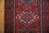 Vintage Karaja rug displaying hooked diamond motif in brick red and sapphire blue.