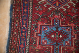 Karaja rug detail: short pile, brick red field, sapphire blue geometric medallion, and blue selvage.