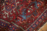 Vintage Karaja rug pile with geometric hook and latch motifs in brick red and sapphire blue.