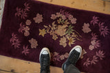 Overhead perspective highlighting the plush, varied pile on the antique Art Deco rug's aubergine field.