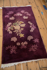 Angled perspective of an antique Art Deco rug's plush, deeply saturated aubergine pile.