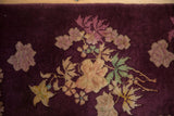 A sculpted Art Deco floral bouquet in mauve and dusty gold on the rich aubergine pile.