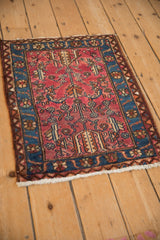 Vintage Lilihan square rug seen from a high angle, with geometric blossoms on a raspberry red field.