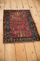 Vintage Lilihan square rug mat viewed at an angle, showing its low pile and polychromatic florals.
