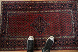 A vintage Engelas rug shown for scale, with its cherry red boteh field and central medallion.