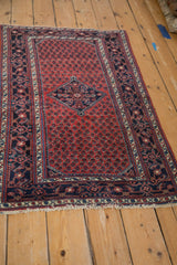 Angled view showing the boteh field and navy Herati-style border of a vintage Engelas rug.