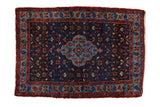 Vintage Persian Bibikabad rug with a scalloped center medallion over an indigo field of floral trellis panels.