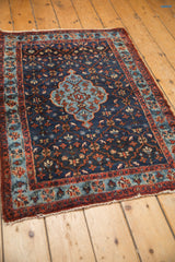 Vintage Bibikabad rug with a deep indigo field and floral trellis design shown in perspective.