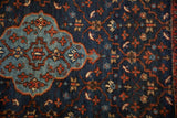 Fine hand-knotted pile of a Persian rug, detailing the sky blue medallion against an indigo trellis.