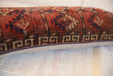 Antique Turkmen rug fragment pillow side with geometric border, red, blue, beige patterns, zipper.