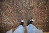 Distressed vintage Mehrivan carpet pile in dusty blush, brown, and seafoam geometric pattern.