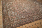 Distressed Mehrivan carpet border with dusty blush, brown, and soft green Herati and vine motifs.
