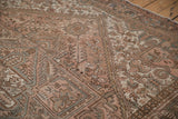 Textured vintage Mehrivan carpet with geometric patterns, buds, and even wear in soft blush, brown.
