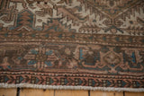 Distressed Persian Mehrivan carpet border with even wear, dusty blush, seafoam, and brown tones, plus fringe.