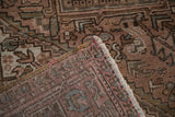 Distressed Mehrivan carpet corner showing softened pile, geometric serrated pattern, and hand-knotted back.