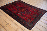 Angled view of a vintage Lilihan rug showcasing its lustrous cherry red wool and fine floral pattern.