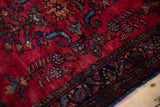 Time-softened cherry red wool pile of a vintage Lilihan with visible foundation knots.
