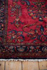 Soft cherry red wool pile with fine curvilinear floral details and small visible white knots.