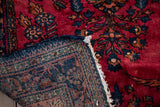 The hand-knotted foundation and cherry red wool pile of a vintage Persian Lilihan rug.