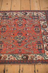 Low angle showing the even pile texture and reciprocating pawn border of a vintage Malayer rug.