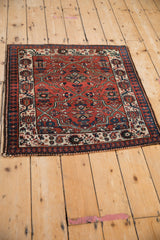 High-angle view of the vintage Malayer rug's corner, showing the reciprocating pawn border.