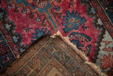 The folded corner of a vintage Persian rug reveals its hand-knotted foundation and pile.