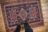 Fringe and geometric borders of antique Karaja rug, dark blue field with red and teal motifs, knot wear.