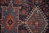 Antique Karaja rug's geometric hook and latch motif in dark blue, madder red, and dusty teal.