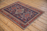 Antique Karaja rug's reciprocating pawn motifs in dark blue, madder red, and ivory.