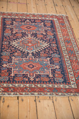 Antique Karaja rug's hook and latch medallion with pawn motif, dark blue, brick red, and wear.
