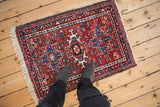 Vintage Karaja rug with red and blue geometric medallions, shown for scale from above.