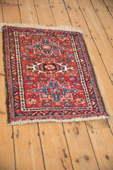 Full angled view of a vintage Karaja rug's geometric medallion in brick red and denim blue.
