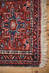 Detail of a vintage Karaja rug's corner, showing the geometric border and neat ivory fringe.
