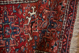 Hand-knotted pile and geometric design of a vintage Karaja rug in brick red and denim blue.