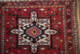 Geometric hook and latch medallion of a vintage Karaja rug, showing ivory and sky blue on a red field.