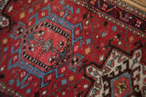 Detail of the vintage Karaja rug's brick red wool pile, showing the texture of the knot heads.