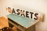 Vintage weathered farmhouse wooden Baskets sign with chippy white and black paint.