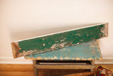 Weathered wooden sign with chippy green paint and exposed natural wood.