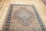 Angled view of a fine antique Tabriz rug's intricate medallion and cypress tree border.