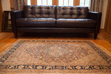 Antique Tabriz collector rug anchoring a room, showcasing its scale and intricate medallion.
