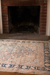 The decorative harmony of an antique Tabriz rug, showing soft blue striations and a detailed cypress border.