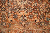 Intricate weave of an antique Tabriz showing soft blue accents on a rust-orange field.