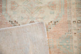 The tightly woven foundation and low, textured pile of a distressed vintage Oushak rug.