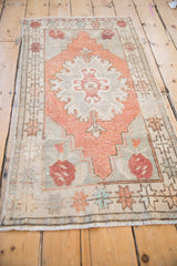 Hook and latch floral motif on distressed Oushak rug with pale terracotta field, even wear.